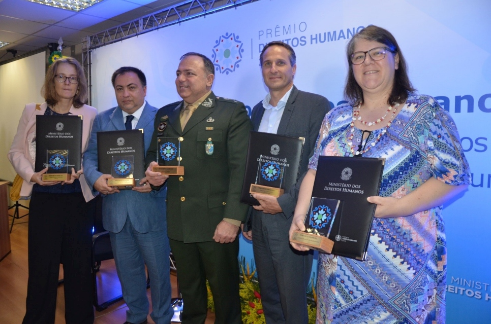Representantes de UNICEF, ACNUR, OIM y UNFPA, así como el comandante de la Operación Acogida, muestran el premio concedido por el Ministerio de Derechos Humanos por su importante actuación en la promoción y defensa de los derechos humanos.