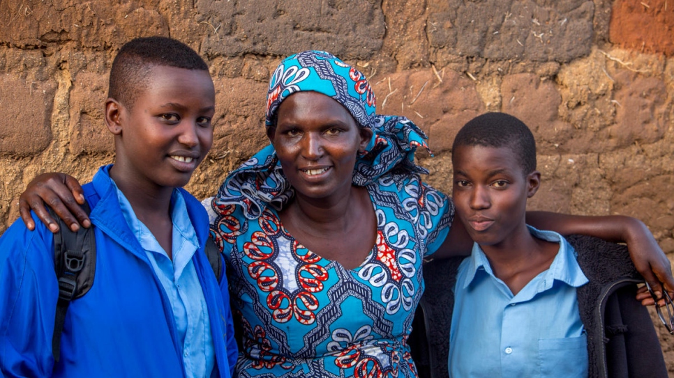 La madre de Bellaca, Compare Yolande (en el medio), afuera de su casa en el campamento de refugiados de Mahama, en Ruanda.