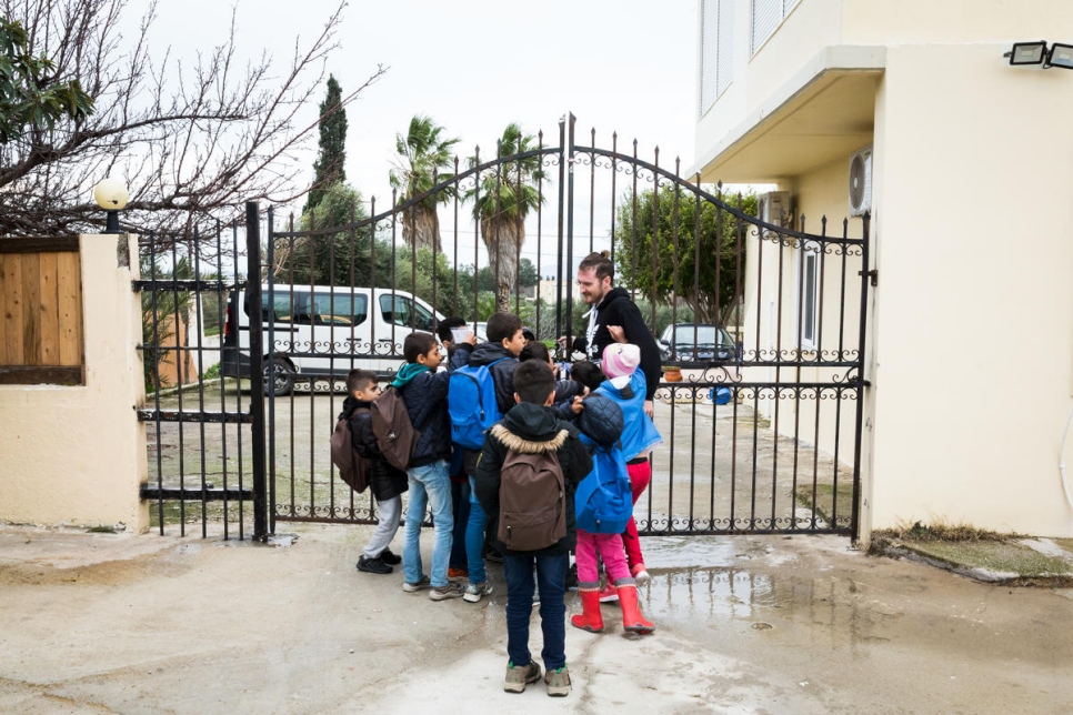 Los niños conversan con uno de sus maestros después de un día de clases. 