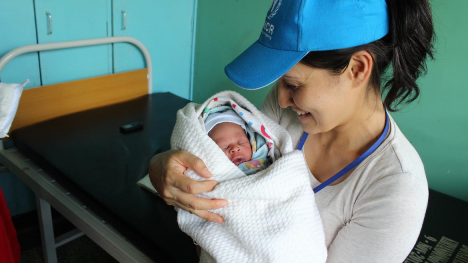 Keiko holds a newborn baby girl from South Sudan at a refugee camp in Uganda.