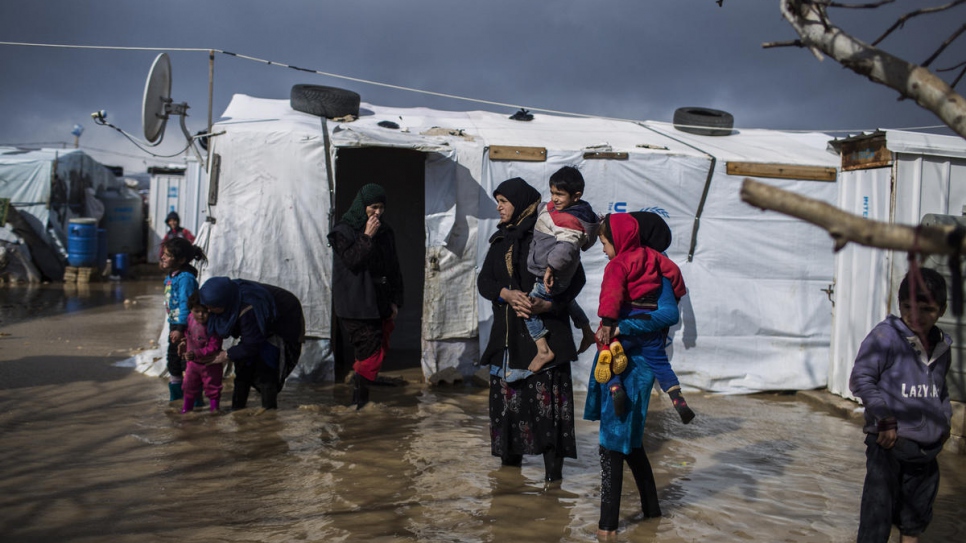 Juriya Ramadan, qui a fui Deir El Zor en Syrie, marche dans les rues inondées de l'installation informelle de Dalhamiya dans la plaine de Bekaa, au Liban. 