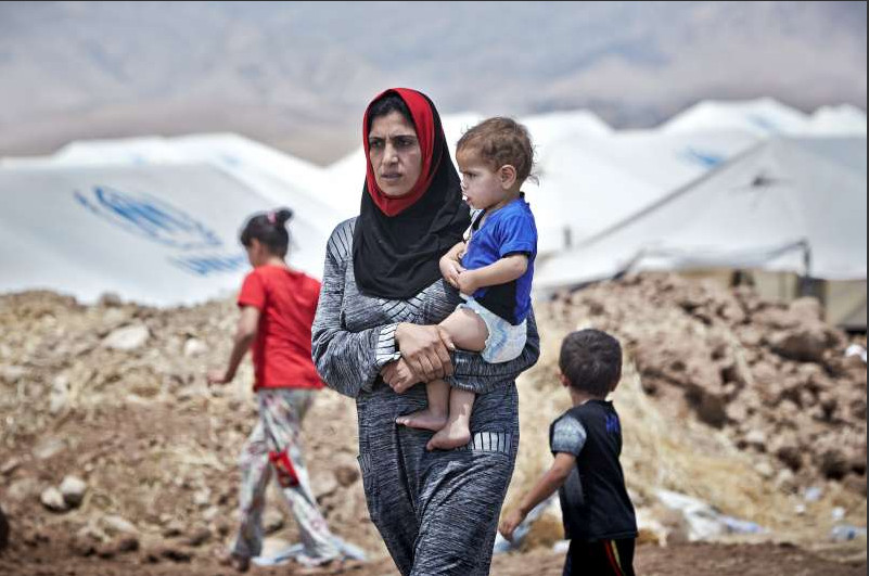 An Iraqi woman from Mosul carries her son at the Garmava transit camp, which is located near a checkpoint on the road between Mosul and Duhok in Iraqi Kurdistan. The camp will have the capacity to host some 3,000 people.