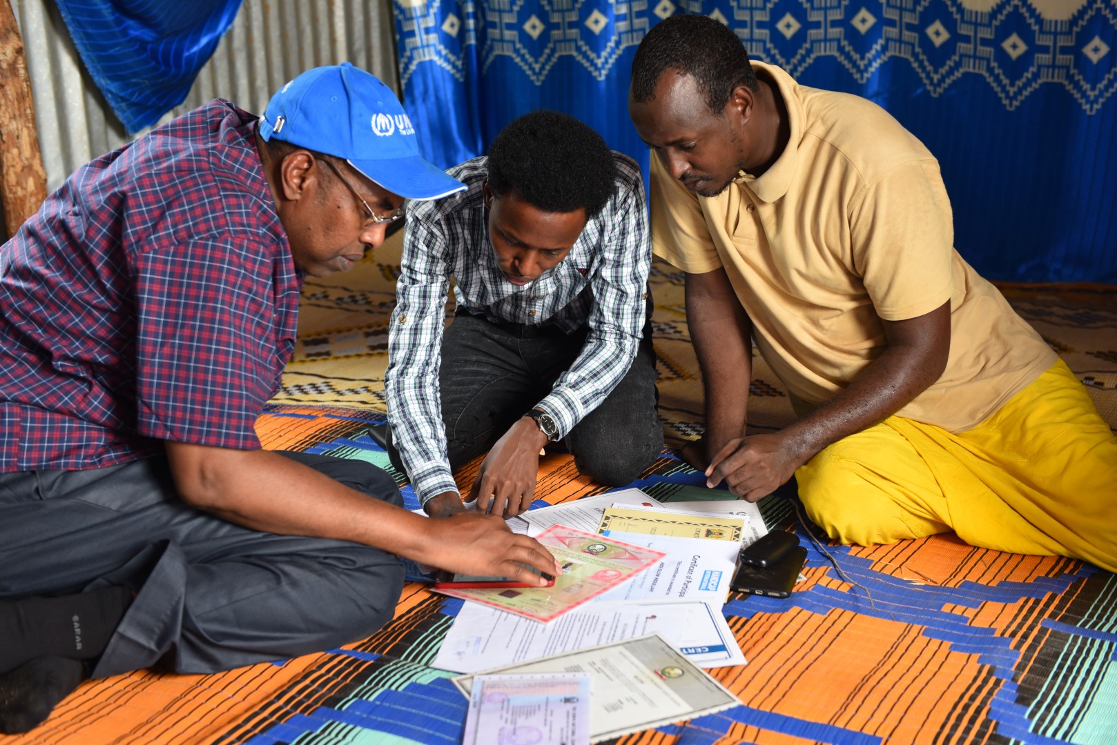 Ambassador Mohamed Affey looks at documents and certificates of 22-year-old, Abdi Abdullahi Olowa during a visit to his family house in Ifo camp of Dadaab. He is among the youth who completed secondary education but is yet to have an opportunity to pursue his higher education. © UNHCR/A.Nasrullah