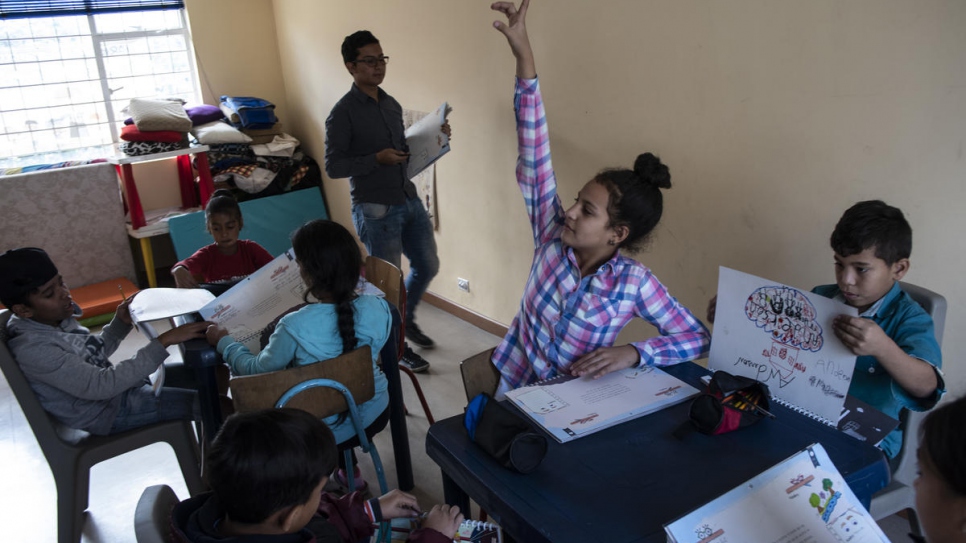 Young Venezuelan, Camila Marcano, 11, raises her hand during an educational activity session at the Hearts Without Borders childcare centre in Bogotá.