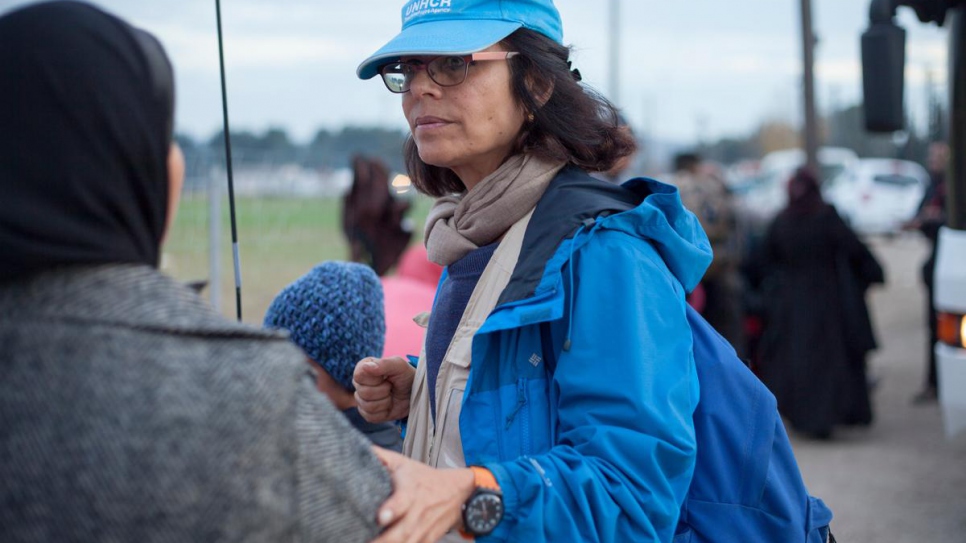 Massoumeh Farman Farmaian s'entretient avec des personnes déracinées à Idomeni, en Grèce, en novembre 2015, et leur explique leur droit de déposer une demande d'asile.  