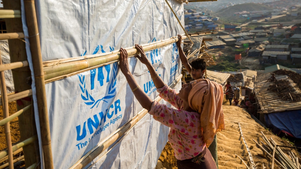 Des réfugiés rohingyas renforcent leur abri dans le camp de Kutupalong à l'aide de matériaux fournis par le HCR. 