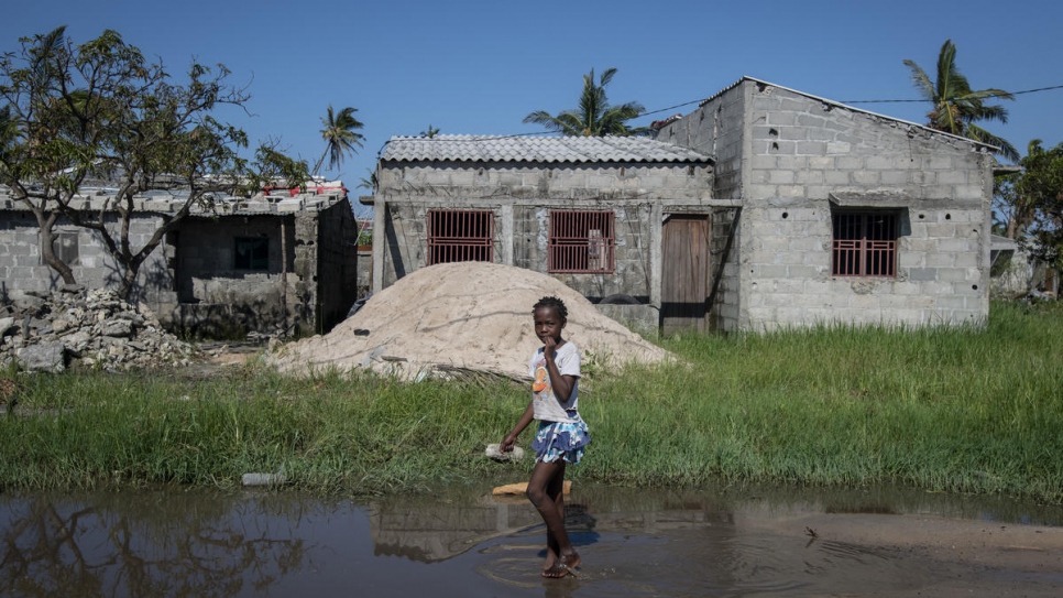 A young girl walks barefoot into the flood waters in the aftermath of Cyclone Idai in Beira, Mozambique.
