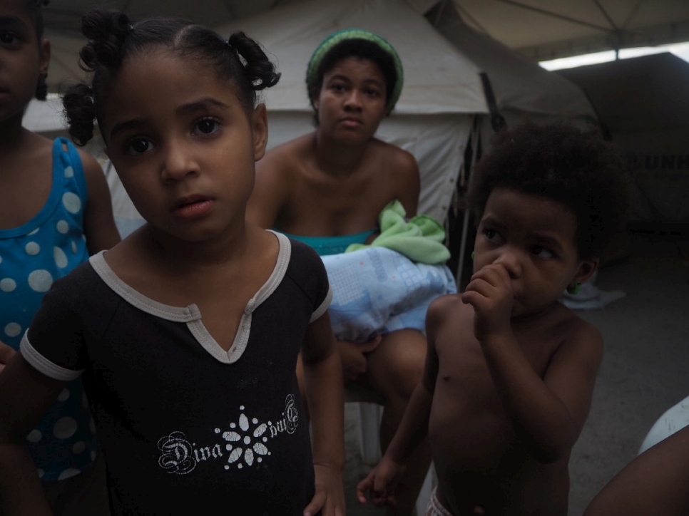 Des enfants et une femme sont photographiés dans une tente du refuge de Jardim Floresta, à Boa Vista, au Brésil. 