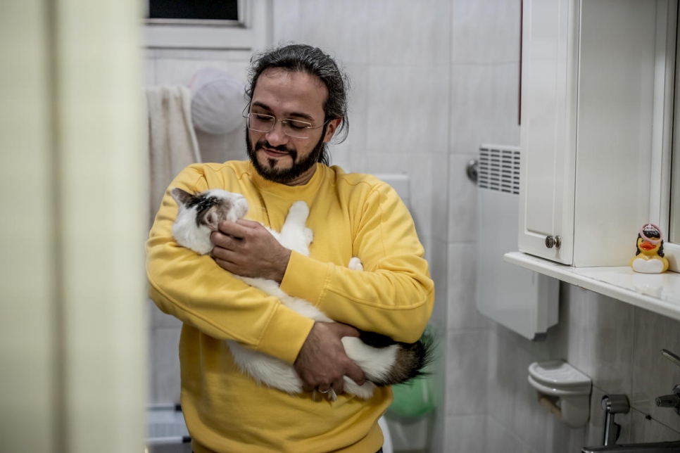 At home in Belgrade, Mawaheb cuddles his cat, Fidel. They have been together since shortly after Mawaheb fled the war in Syria.