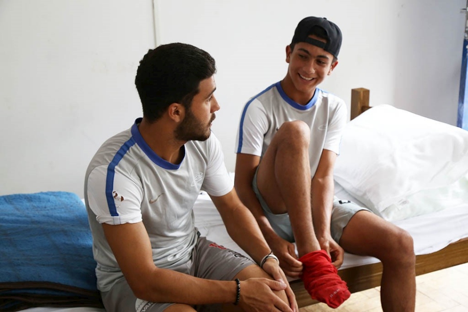 Dos jóvenes jugadores refugiados se preparan para realizar una sesión de entrenamiento en la Academia de Fútbol Pérolas Negras en Resende (Río de Janeiro).