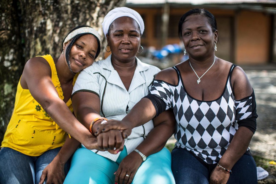 2014 - Mariposas de Alas Nuevas es una red compuesta por alrededor de 120 voluntarias principales. Cada mujer tiene la tarea de reclutar a cinco mujeres nuevas para que su alcance se amplíe. El grupo se describe como una "red de protección de mujeres que ayudan a las mujeres en el conflicto armado". Parte de su estrategia es mantenerse al margen de los grupos armados -de los cuales hay muchos- en Buenaventura, Colombia. De izquierda a derecha: Maritza Yaneth Asprilla Cruz de 49 años, desplazada interna con 3 hijos: el mayor murió en un trágico accidente. Sufrió de violencia doméstica por su padrastro, se hizo cargo de sus hermanos a muy temprana edad; a los 9 años comenzó a trabajar como empleada doméstica y a los 36 años recibió su diploma de escuela secundaria. Ahora estudia para convertirse en enfermera y enseña a las mujeres sobre autocuidado. Gloria Amparo Arboleda Murillo, desplazada interna de 49 años, cofundadora de la red, madre soltera de dos hijas, se crió en la pobreza extrema; crió a 4 de sus hermanos desde los 7 años (madre discapacitada). En el 2008 ayudó a generar apoyo para una nueva ley para salvaguardar los derechos de las mujeres y la prevención de violencia sexual y de género. Ha enfrentado amenazas directas luego de ayudar a una madre e hija que sufrieron violencia doméstica. Mery Medina de 50 años, madre soltera y en riesgo de desplazamiento. Coordina un grupo de 30 mujeres cuyos esposos/ hijos han sido asesinados o han desaparecido. Ayuda a mejorar su economía ofreciendo talleres de cocina y costura. Trabaja con sobrevivientes de violencia sexual y de género paraa hablar y expresar su emociones. No tenía dinero para estudiar, pero su sueño siempre ha sido convertirse en trabajadora social.