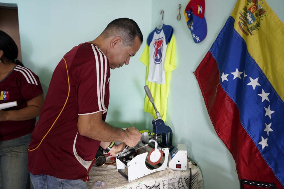 Ramiro operando una máquina de impresión, que esperan poder volver a poner en marcha.