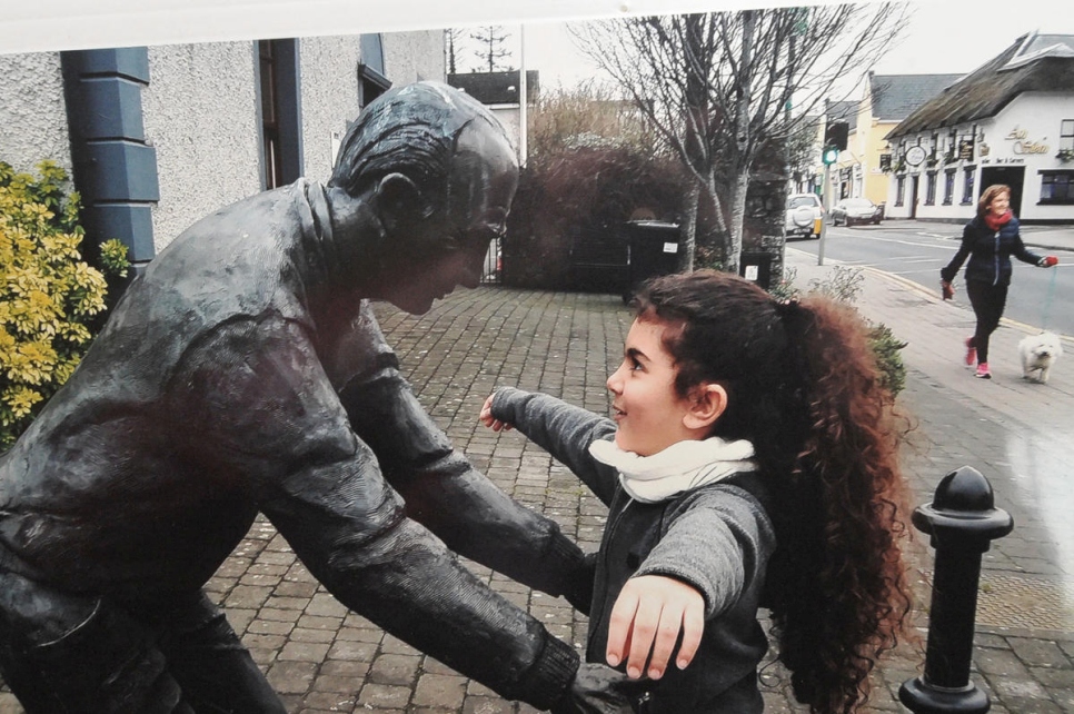 Lorca Fakir frente a Welcome Statue en su nueva ciudad, Dunshaughlin, Condado de Meath, Irlanda.