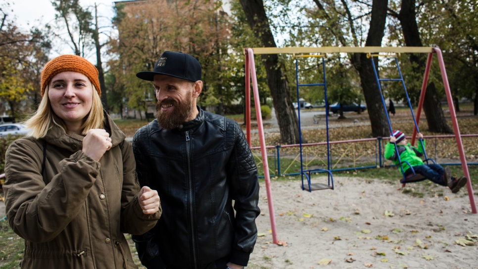 Anna y Gesha cantan juntos mientras su hijo menor, Igor, juega en el columpio en el parque de juegos cerca de su apartamento.