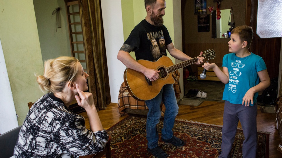 Anna, Gesha e Igor hacen una presentación en casa. Igor nació sordo y con autismo, y ahora aprende lenguaje de señas junto a su madre.