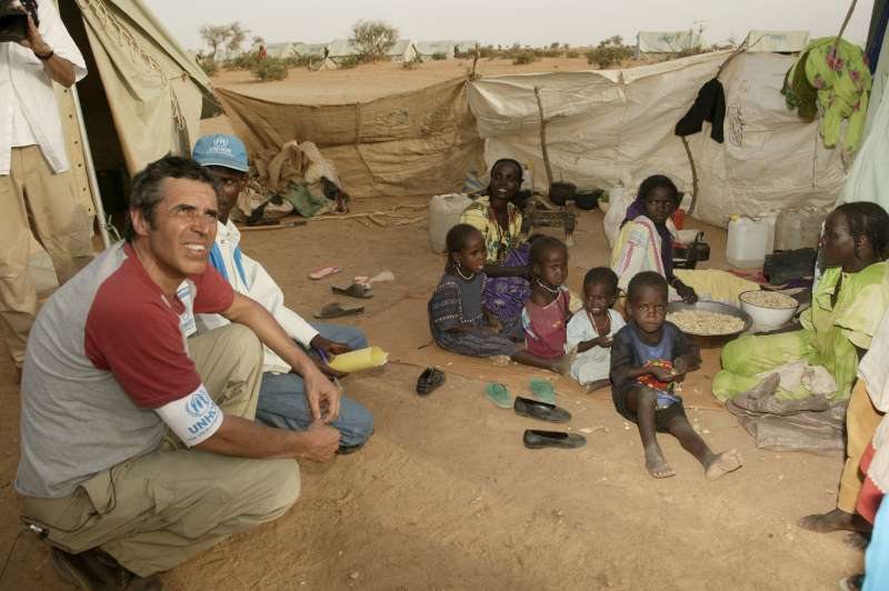 Julien Clerc, Embajador de Buena Voluntad de ACNUR, escucha las dificultades de una familia de refugiados en el campo de Kounoungo, en Chad oriental, 3 de marzo de 2004. 