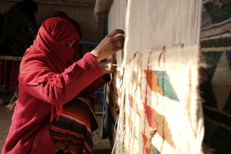 Una tejedora hace una alfombra en la provincia norteña de Balkh, Afganistán, en diciembre de 2017. La mujer y su familia son desplazadas de la provincia de Faryab y llegaron a Balkh en 2017. 