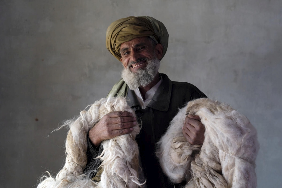 Un retornado afgano sostiene la lana que escogió para las hilanderas. El hilo es para hacer alfombras y kilims como parte del proyecto de medios de vida basados en la comunidad de ACNUR en Kabul, diciembre de 2017. 