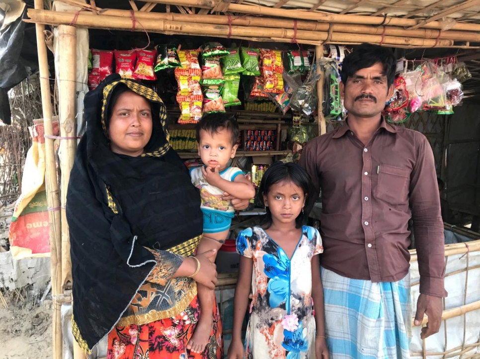 نورول سلام وزوجته لالو بيغوم مع اثنين من أطفالهما أمام محل بيع الشاي الذي يديرانه في مخيم كوتوبالونغ في بنغلاديش.

