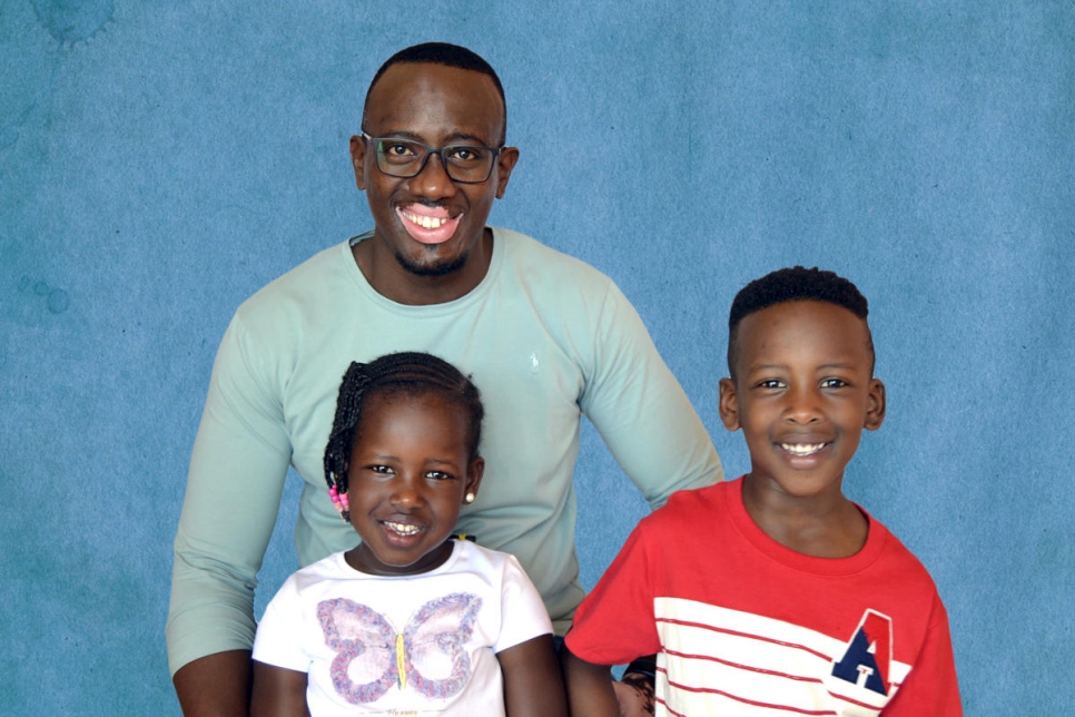 Jackson Musoni posa con dos de sus tres hijos, diciembre de 2018.