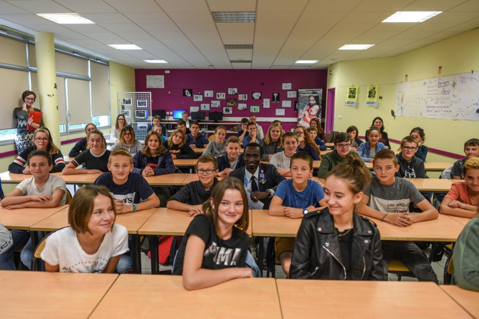 Hassan Mahamat, de Sudán, en el centro de la fotografía, se sienta con los alumnos en el Collège Octave Mirbeau en Trévières. Les contó sobre su viaje a través de Libia y el Mediterráneo. 