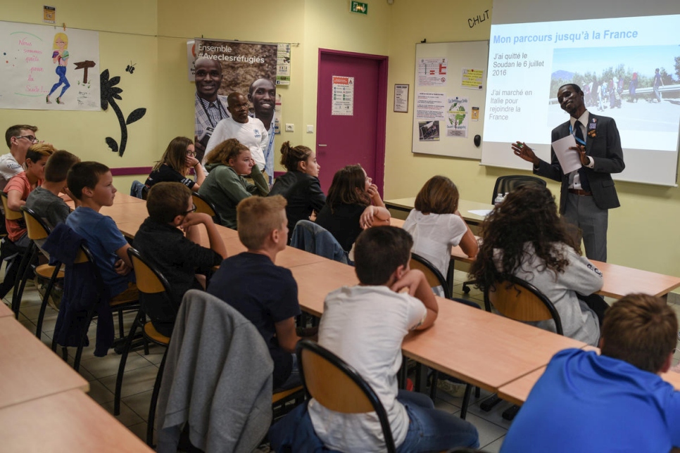 Los alumnos escuchan al refugiado sudanés Hassan Mahamat contar la historia de su viaje a Francia a través de Libia y el Mediterráneo. 