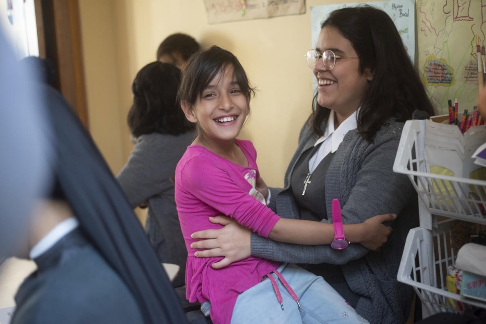 طفلة فنزويلية تتفاعل مع متطوع في مركز "قلوب بلا حدود" لرعاية الأطفال في بوغوتا.
