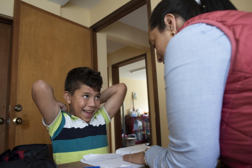 مديرة مركز "قلوب بلا حدود" لرعاية الأطفال ساندرا رودريغيز تعطي تعليمات فردية للطفل الفنزويلي أندرسون أريناس البالغ من العمر 11 سنة.