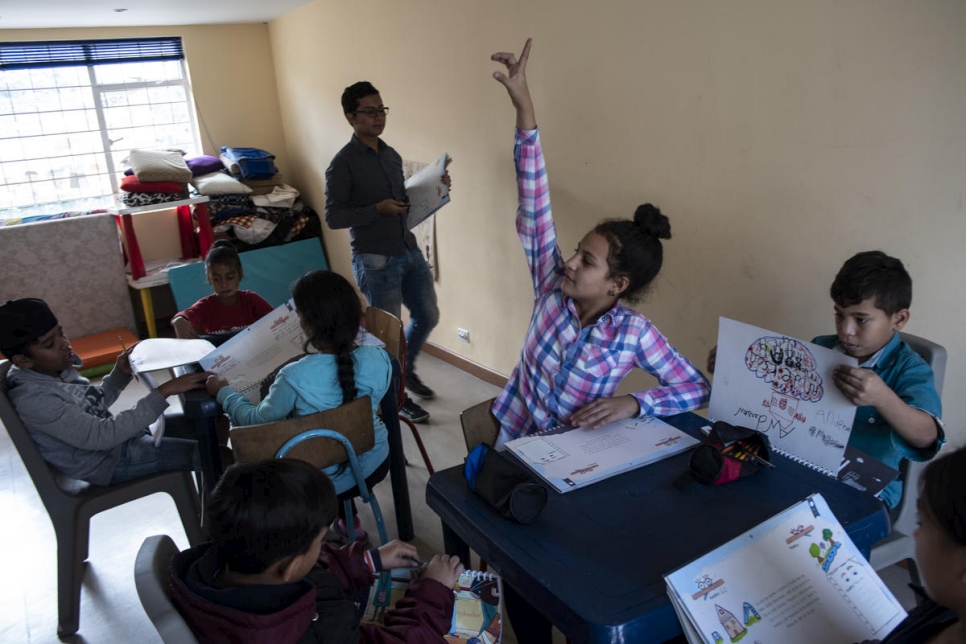 Camila, una niña venezolana de 11 años, levanta la mano durante una actividad educativa en el centro de cuido Corazón Sin Fronteras, en Bogotá.