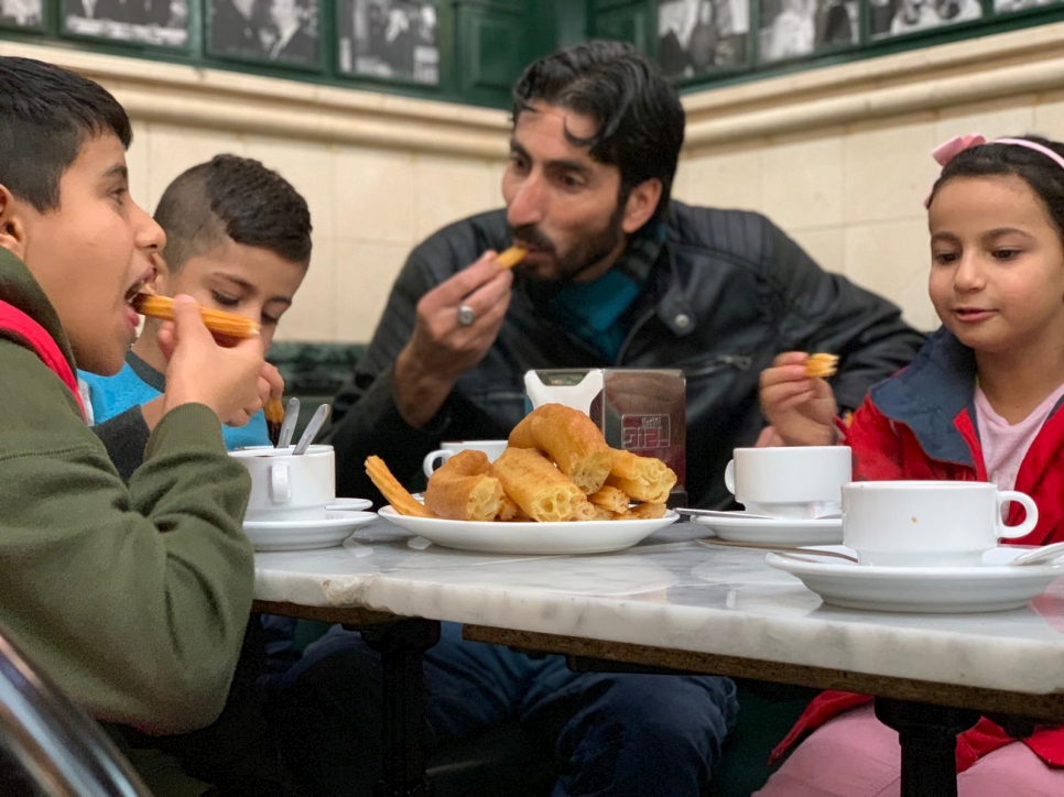 Alí y su familia, de Siria, llegaron a Madrid hace apenas tres meses y todavía se están acostumbrando a la cocina española. En la popular chocolatería madrileña de San Gines de Madrid, prueban la especialidad local, churros con chocolate caliente. "Esta antigua cafetería me hace sentir nostalgia por los cafés de mi ciudad natal, Alepo", explica Ali, que huyó de Siria hace 7 años.