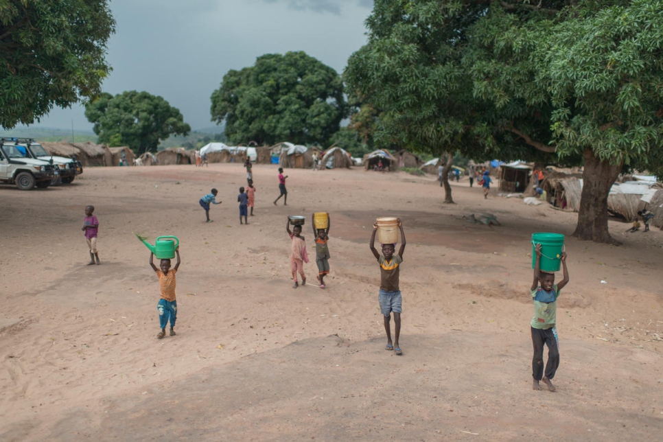 Niños congoleños llevando agua a sus albergues en Kaseke, un sitio para desplazados internos en la provincia de Tanganyika devastada por la guerra. 