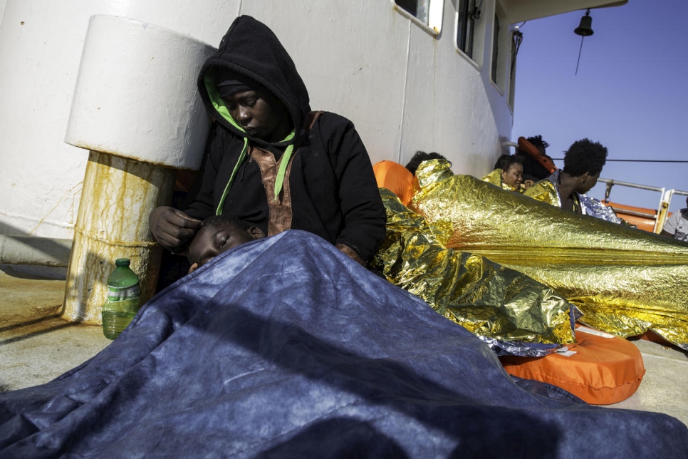 Fátima, quien huyó de la epidemia de ébola en Sierra Leona, mece a su hijo Daniel a bordo del barco de búsqueda y rescate Sea Watch en el mar Mediterráneo, en 2016. 