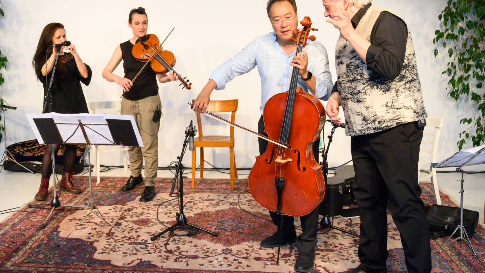 Cellist Yo-Yo Ma plays with refugees at a music workshop in Vienna. 