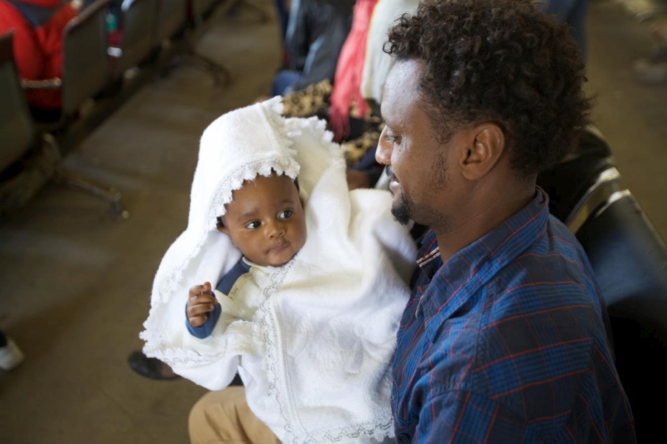 Un hombre eritreo acuna con orgullo a su hija mientras espera ser evacuado a Níger. 