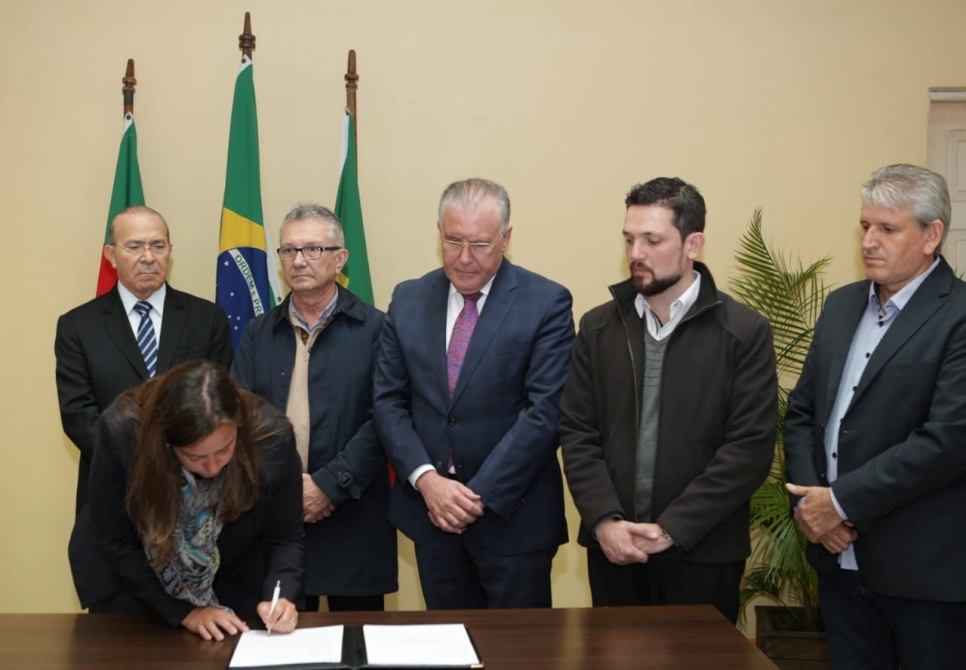 La representante de ACNUR en el Brasil, Isabel Márquez, firma el acuerdo de cooperación entre los ministerios de Desarrollo Social, la Casa Civil, las alcaldías de Canoas y Esteio (Rio Grande do Sul) y la Asociación Antônio Vieira (ASAV). 