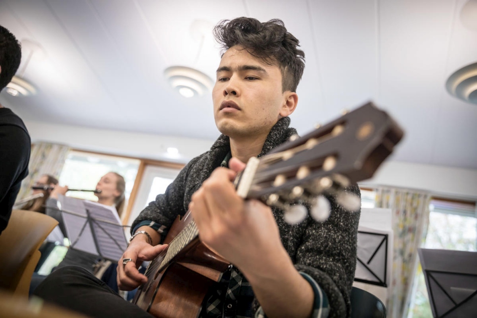 Amir Vafa, nacido en Afganistán, de 20 años, toca la guitarra durante un ensayo. 