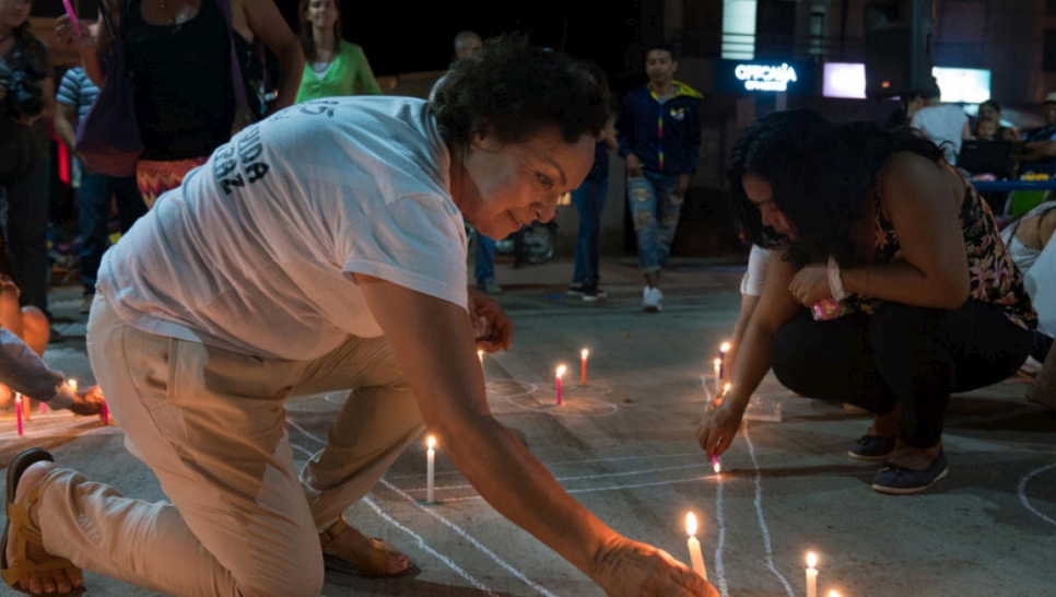 Fátima Muriel, fundadora y presidenta de la Alianza Mujeres Tejedoras de Vida, enciende una vela en un evento comunitario por el "Día de las Velitas" en Putumayo, Colombia.
		