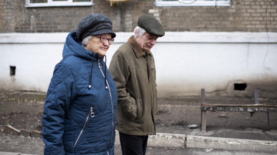 Valentyna and Volodymyr go for a walk outside their new home in the city of Toretsk.