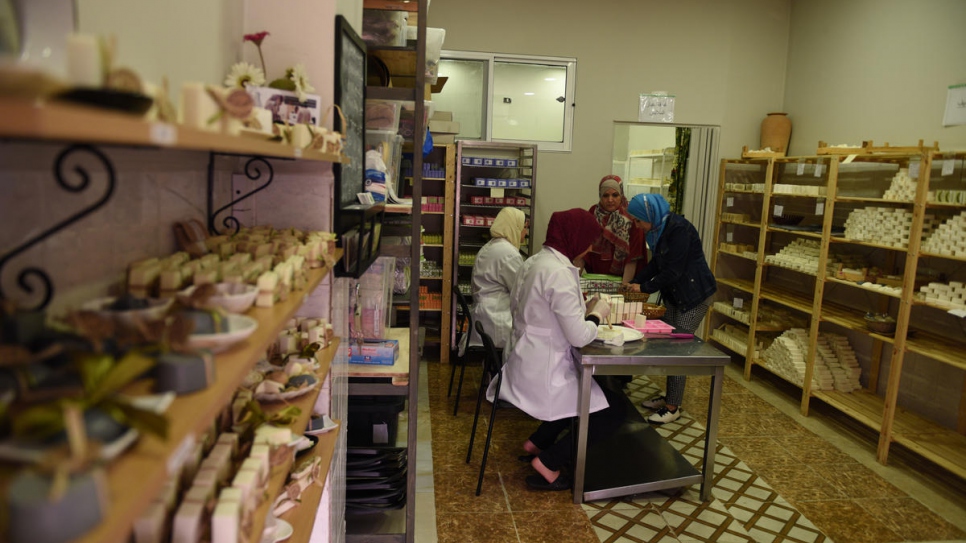 Najwa (rear) and her employees prepare orders at their shop in Zarqa, Jordan.