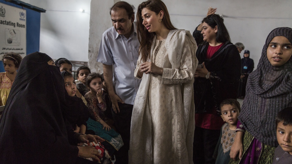 Pakistani actor Mahira Khan speaks with Afghan refugees at a UNHCR voluntary repatriation centre in Peshawar, Pakistan. The refugees are preparing to return home to Afghanistan.