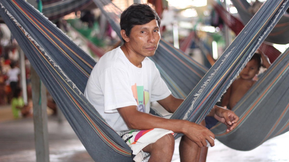 Eligio Tejerina, un chef communautaire Warao de 33 ans, assis dans un hamac à côté de ses enfants dans leur abri de Pintolandia à Boa Vista, dans le nord du Brésil. 