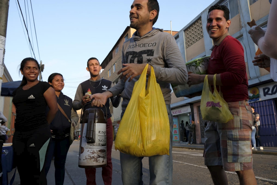 لويس أنطونيو بيريز (وسط)، 24 عاماً، من باركيسيميتو في فنزويلا، يبيع الشوكولاتة الساخنة والخبز الحلو خارج مقر الهجرة في ليما، البيرو، برفقة زميلين فنزويليين من الباعة المتجولين.