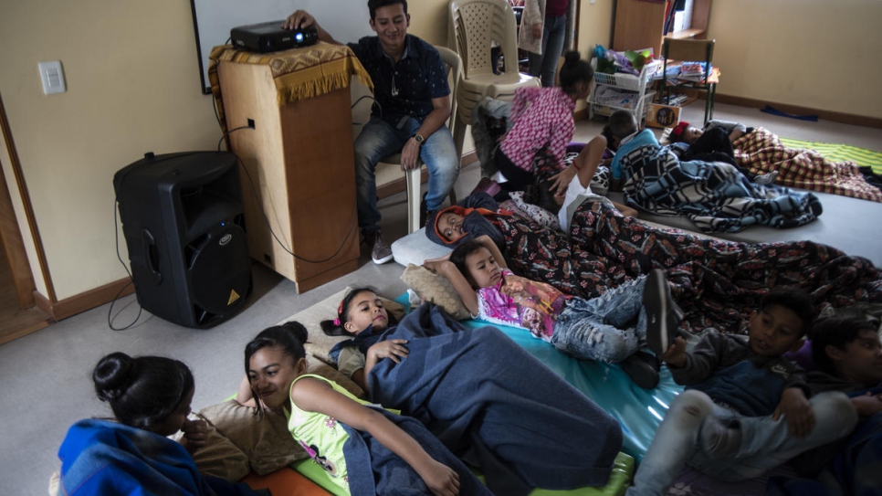 Des enfants migrants et réfugiés vénézuéliens regardent le film Ratatouille à la garderie de Hearts Without Borders à Bogota. 
