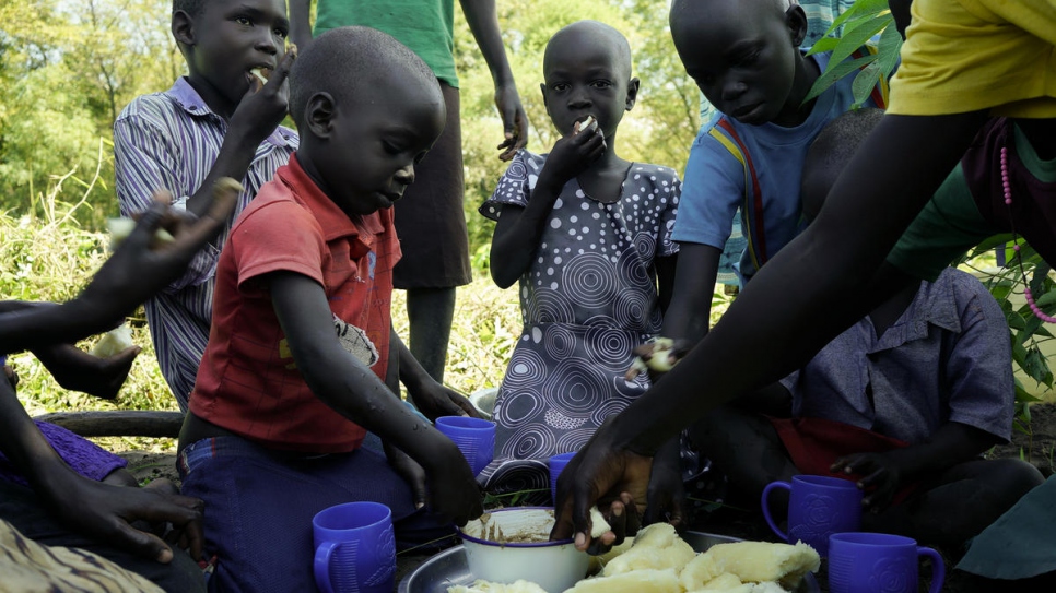 Children take a break for lunch after helping their mother Queen.