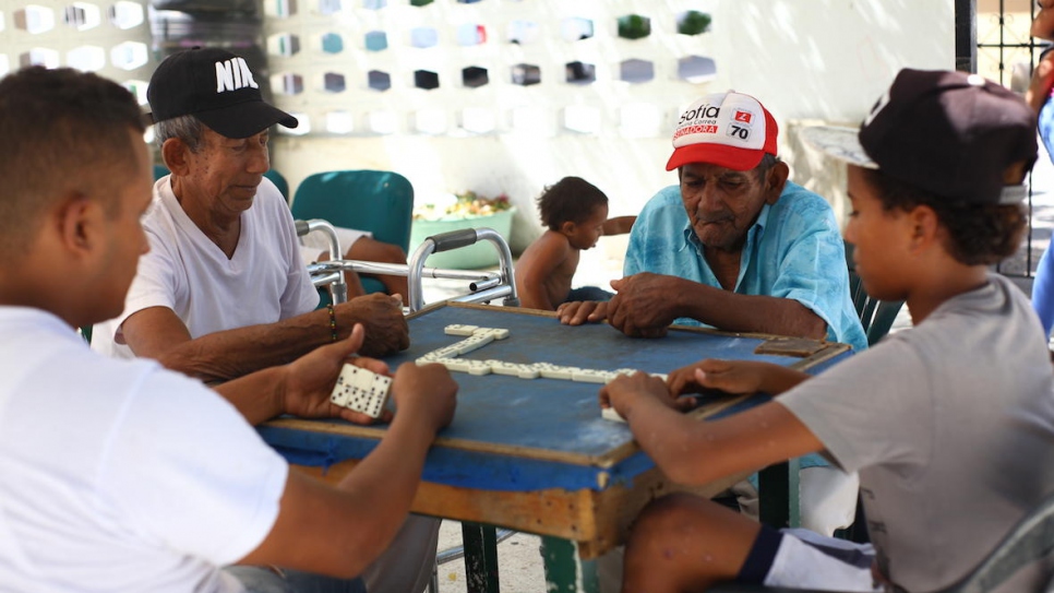 Partie de dominos entre des Colombiens âgés et de jeunes Vénézuéliens à la Maison de Grand-père à Riohacha, nord de la Colombie. 