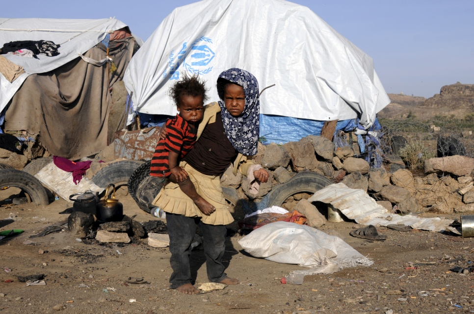 Rahaf, une déplacée yéménite âgée de 8 ans, porte son petit frère de 2 ans dans l'installation de Dharawan à Sanaa, au Yémen. Photo d'archives, mai 2017. 