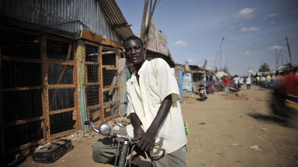 A bicycle taxi rider stands ready for hire in Kakuma refugee camp, Kenya.