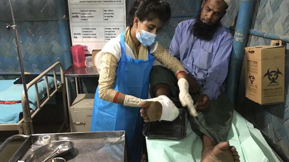 Sarmin Aktar Sathi, a nurse at a 24-hour clinic in Kutupalong, treats Mohammad Sharif, a patient who still bears the scars of violence he fled in Myanmar in 2017.