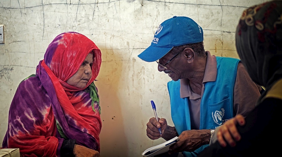 Une femme yéménite ayant fui les combats à Al-Hodeïda discute avec un employé du HCR dans un centre d'accueil informel, à Aden. 