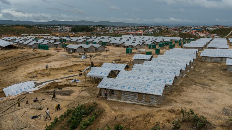 Workers finalize construction of new shelters for families relocated from homes at greatest risk of landslides and flooding in Kutupalong refugee settlement, near Cox's Bazar, Bangladesh.